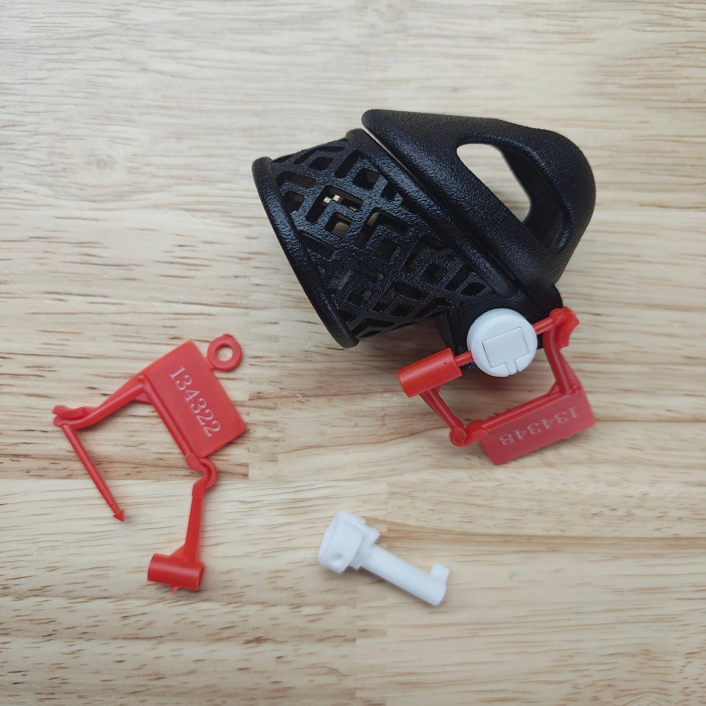 Black and red plastic components on a wooden surface