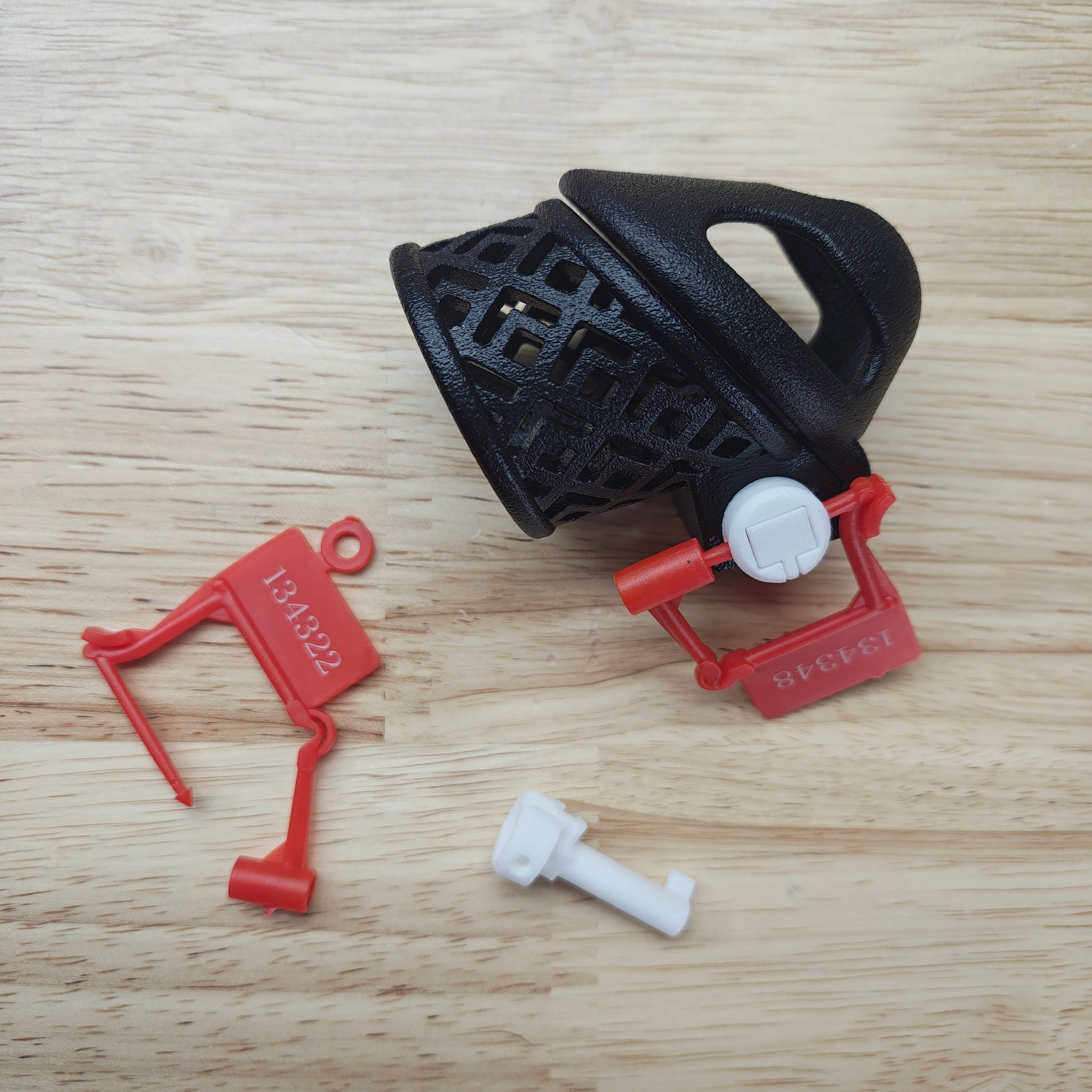 Black and red plastic components on a wooden surface